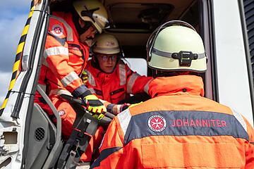 Mehrere Einsatzkräfte versorgen eine Darstellerin im Fahrerhaus eines LKW.