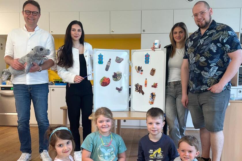 Praxisteam mit den Kindern und Schautafel