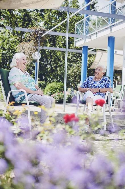 Zwei Bewohnerinnen sitzen im Garten des Johanniter-Pflegewohnhaus Haus Kielwein