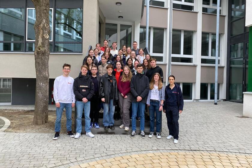 Eine Gruppe von Schülern steht vor der Schule. 