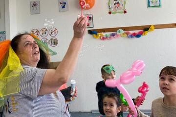 Eine Mitarbeiterin macht Seifenblasen für die Kinder.