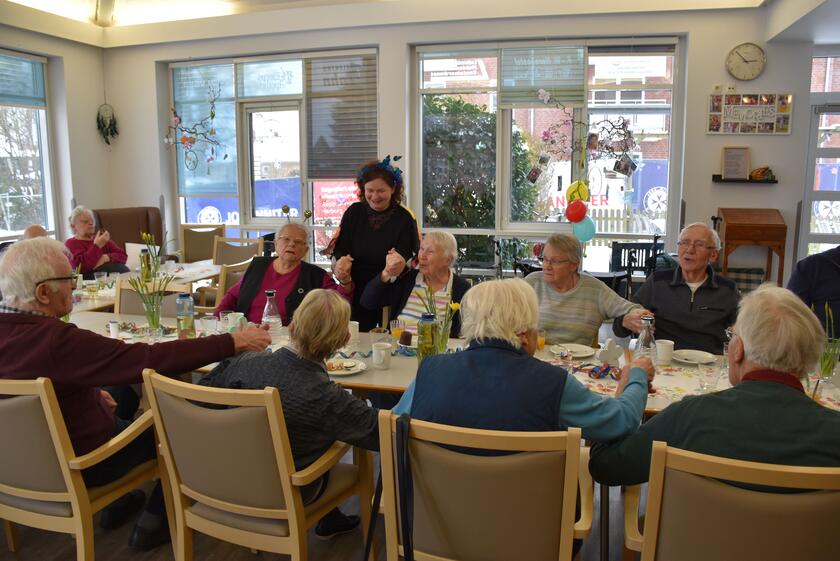 Die Gäste der Johanniter-Tagespflege sitzen an der Kaffeetafel und schunkeln zu Faschingsmusik