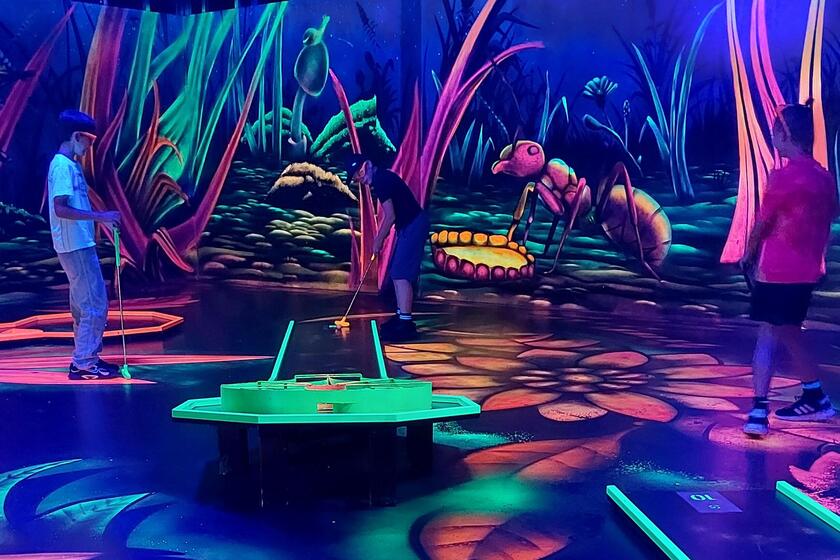 Schüler spielen Schwarzlicht-Minigolf