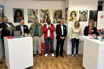 Einige Mitarbeitende und Unterstützende in einer Reihe vor Kunstwerken