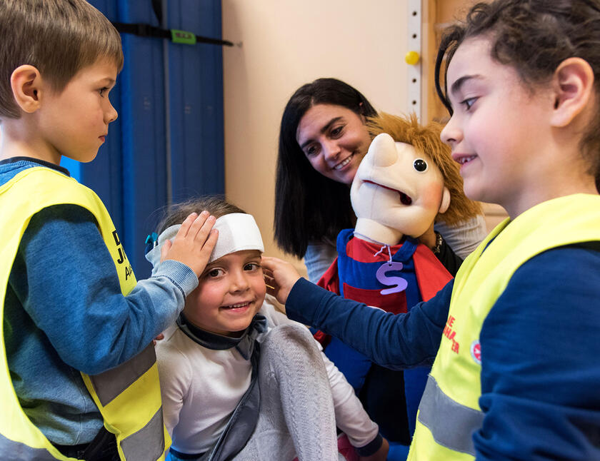Wie legt man einen Kopfverband an? Das lernen Kinder bei den Blaulichtzwergen.