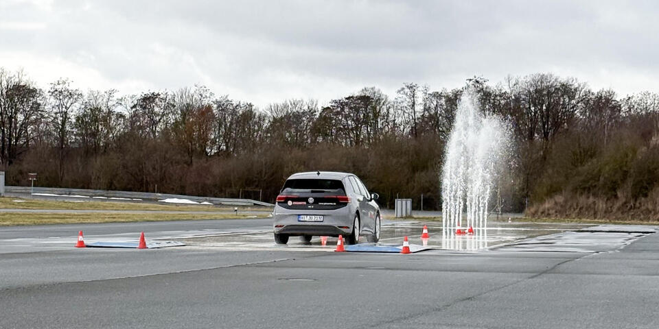 Ein Auto fährt auf eine Wassersäule zu.