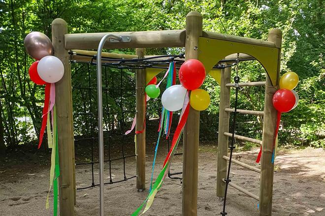 Ein Klettergerüst ist mit Ballons und Luftschlangen dekoriert.
