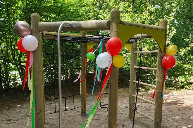 Ein Klettergerüst ist mit Ballons und Luftschlangen dekoriert.