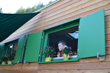 Ein Kind schaut aus dem Bauwagen