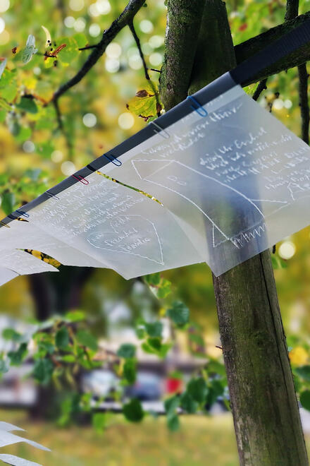 Beschriftete Glass Folien hängen an Bäumen.