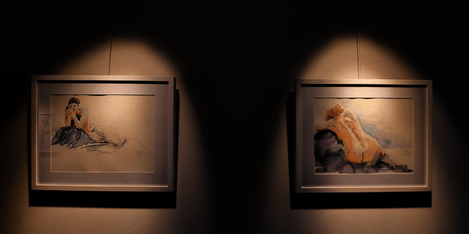 zwei Aquarellbilder, die von scheinwerfern beleuchtet sind