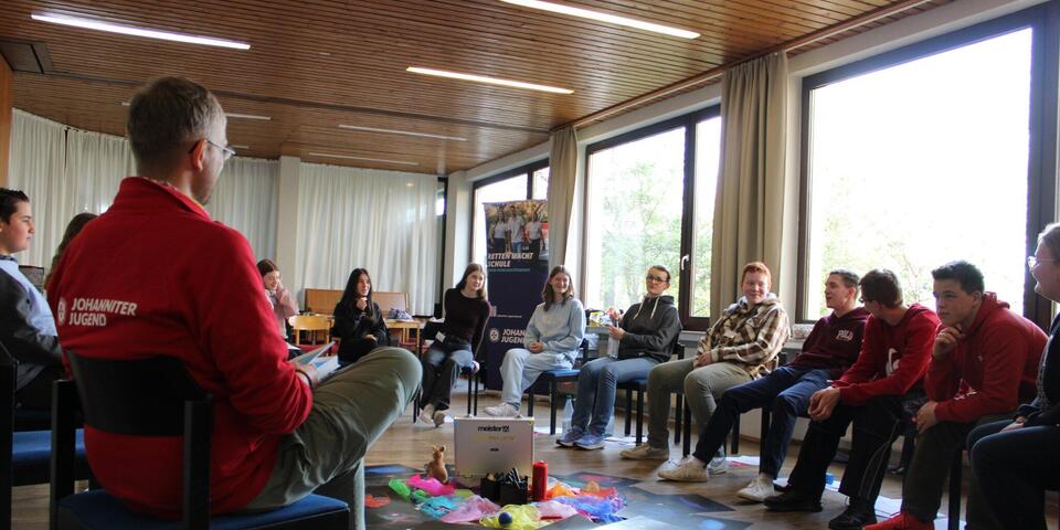 Gruppe im Sitzkreis mit !ACHTUNG-Material