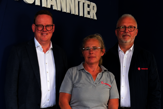 Gruppenbild mit zwei Herren und einer Dame in Johanniter-Shirt.