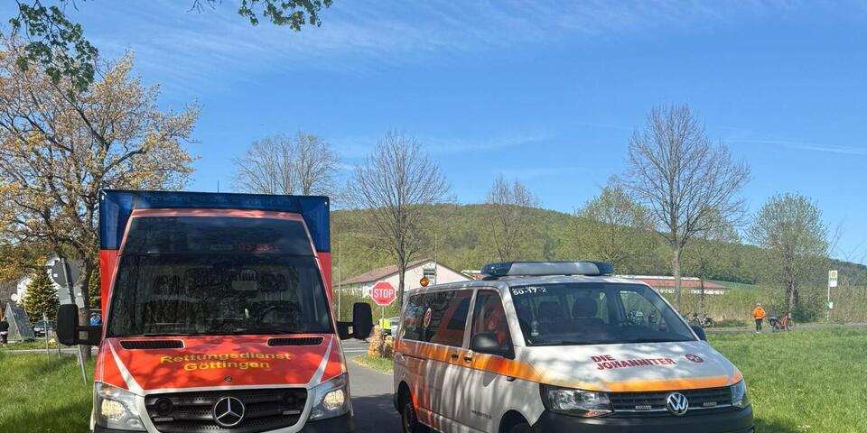 Ein Rettungswagen und ein Mannschaftstransportwagen stehen auf einer Landstraße.