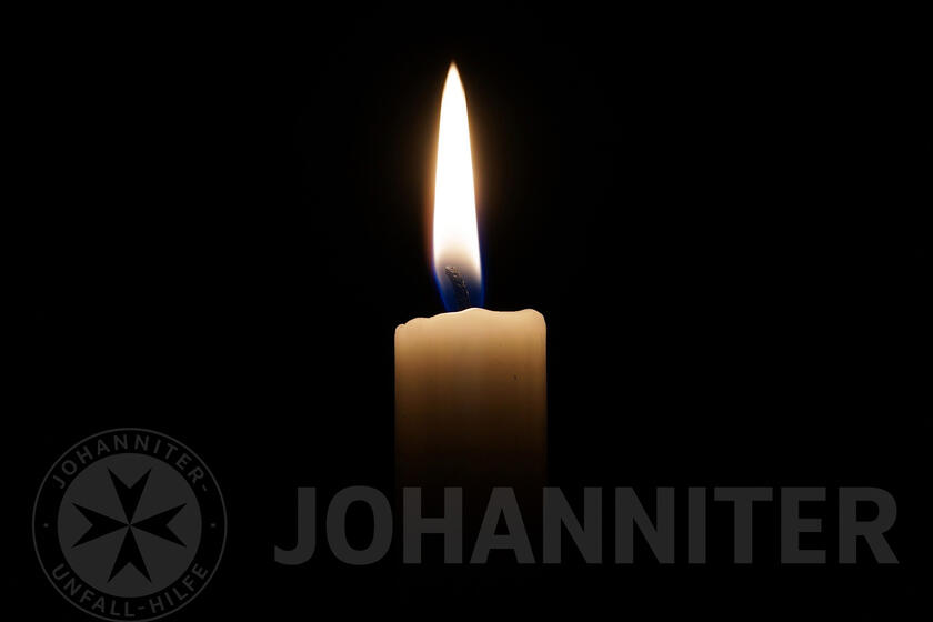 Kerze vor dunklem Hintergrund.