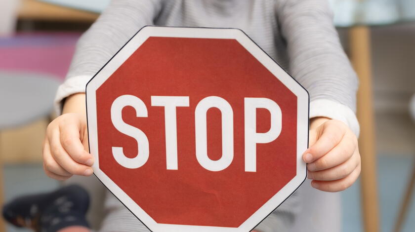 Kinderhände mit Stoppzeichen in der Hand 