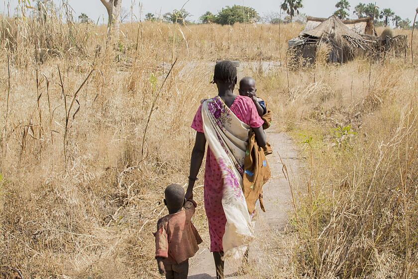Eine Frau mit ihren zwei Kindern auf dem Weg nach Hause