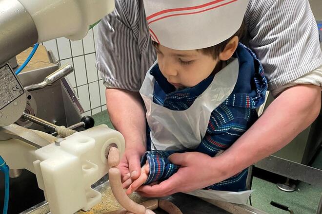 Kindergartenkind darf selber Würste mit Hilfe herstellen