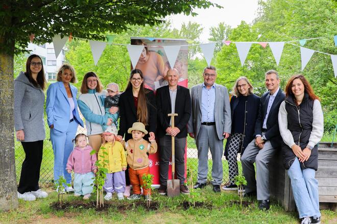 9 Erwachsene und 3 Kinder stehen für ein Gruppenbild vor den gespendeten Johannisbeersträuchern
