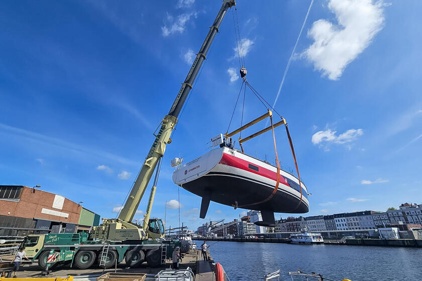 Ein Kran lässt das Segelboot der Johanniter zu Wasser.