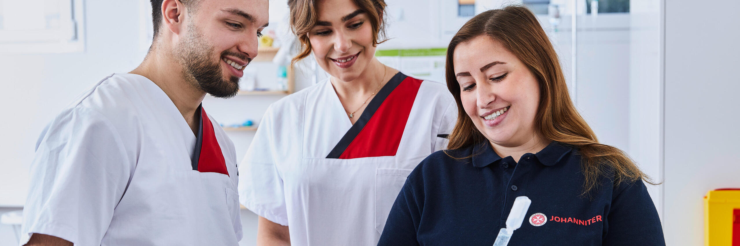 Zwei Auszubildende in der Pflege hören der Dozentin zu