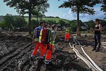 Rettungskräfte der Johanniter sprechen mit einer Betroffenen im Ahrtal.