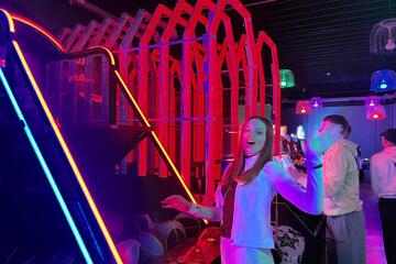 Ein Mädchen wirft Bälle an einem Spielgerät