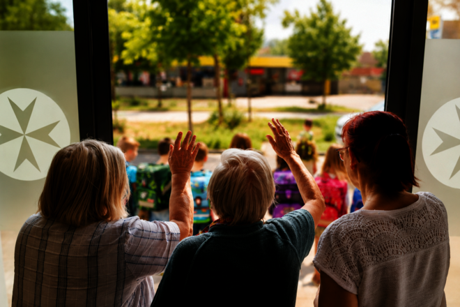 Seniorinnen winken Vorschulkindern