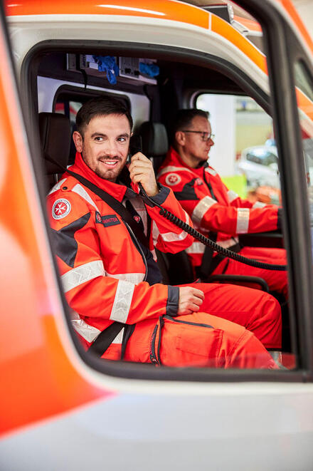 Ein Notfallsanitäter der Johanniter telefoniert im Einsatzfahrzeug.