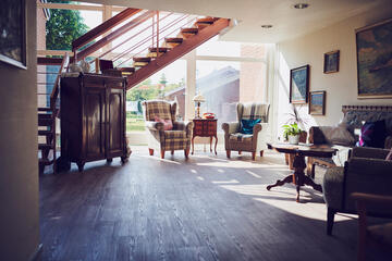 Sonnige dekorative eingerichtete Diele mit zwei Sessel und weiteren Sitzgelegenheiten 