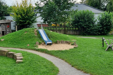 Rutsche umgeben von Grünflächen. 