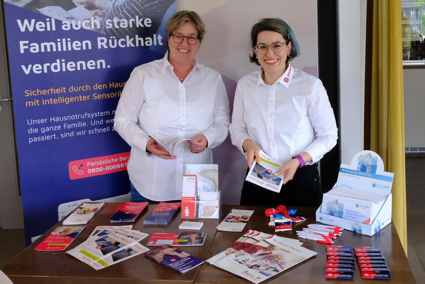 Mitarbeiter am Infostand zum Tag der Pflege im Supermarkt