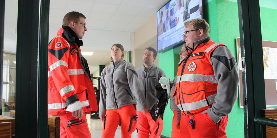 Johanniter besprechen sich in einem Schulgang