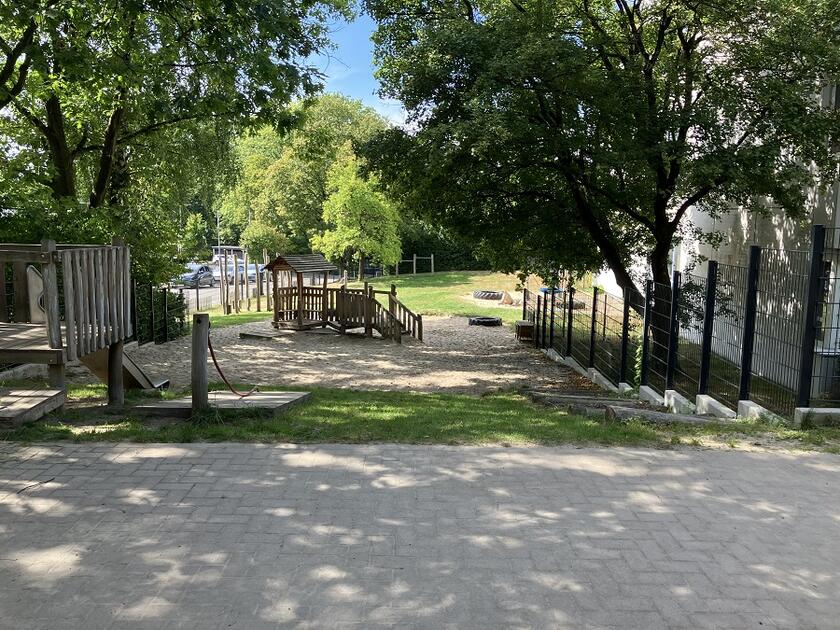 Blick auf das Aussenbereich der Kita mit Spielplatz
