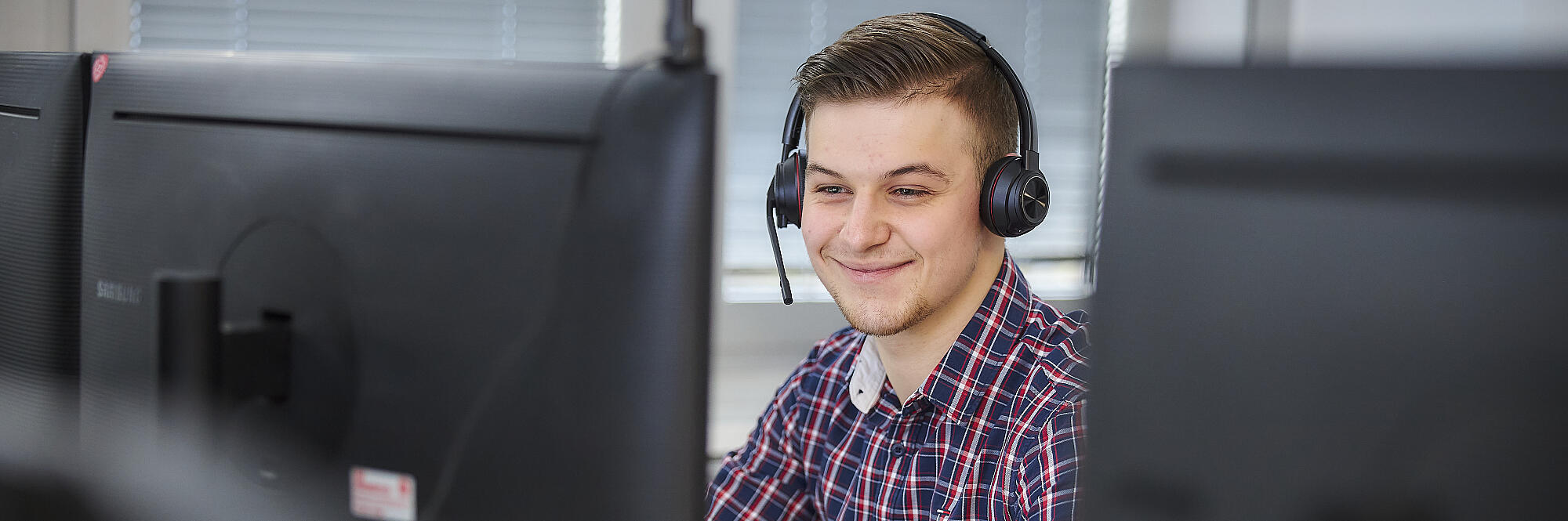 Mitarbeitende Person vor PC-Bildschirm