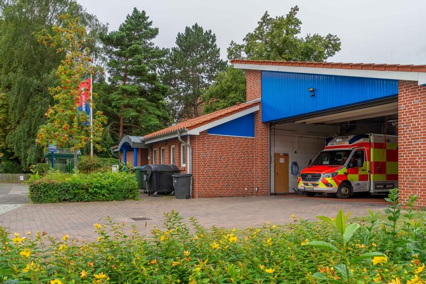 Ein Rettungswagen steht in der Fahrzeughalle Cismar. Die Rettungswache ist von der Seite her zu sehen.