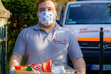 Johanniter-Helfer mit Einkäufen während der Corona-Pandemie.