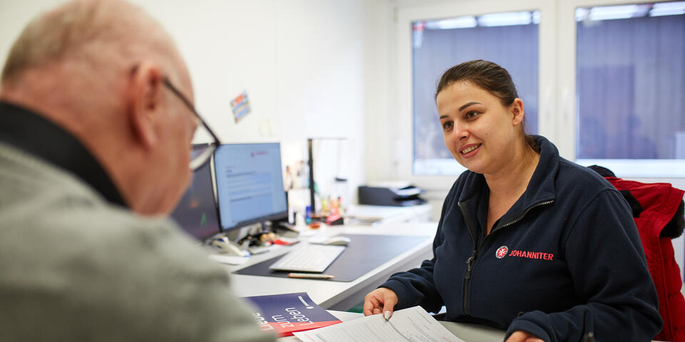 Eine Mitarbeiterin der Johanniter-Fluthilfe berät einen Anwohner.