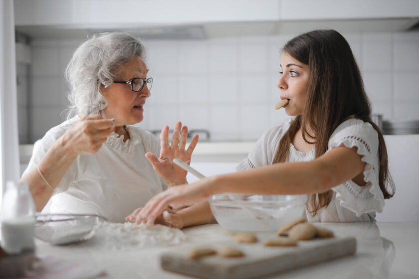 Eine ältere und eine junge Frau backen gemeinsam.