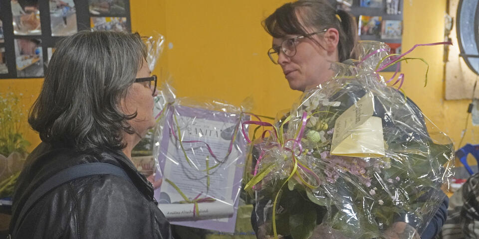 Eine Frau überreicht einer anderen Frau ein Geschenk