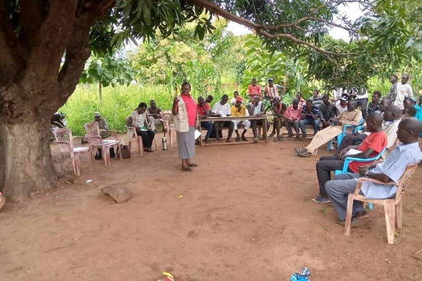 Eine Person steht in der Mitte eines Stuhlkreises