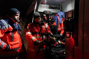 Zwei Ehrenamtliche überprüfen das Tauchequipment am Einsatzwagen.