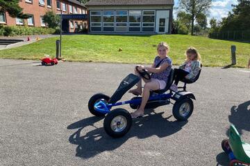 Zwei Jungs fahren mit einem Tretfahrzeiug