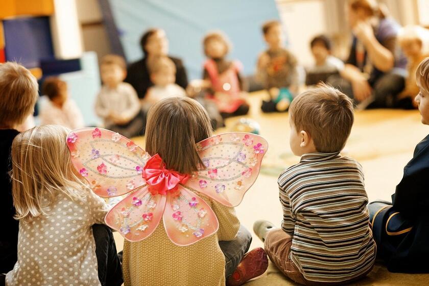 Kinder sitzen im Kreis auf dem Boden