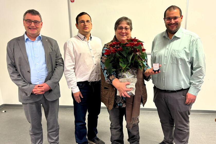 Christine Zeitler (langjährige Mitarbeiterin der Johanniter) erhält zur Verabschiedung einen Blumenstrauß und eine Gedenkmünze.