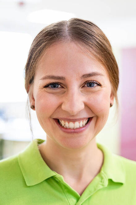 Eine Pflegekraft der Johanniter blickt lächelnd in die Kamera