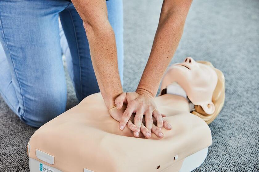 Eine Kursteilnehmerin übt die Reanimation an einer Übungspuppe.