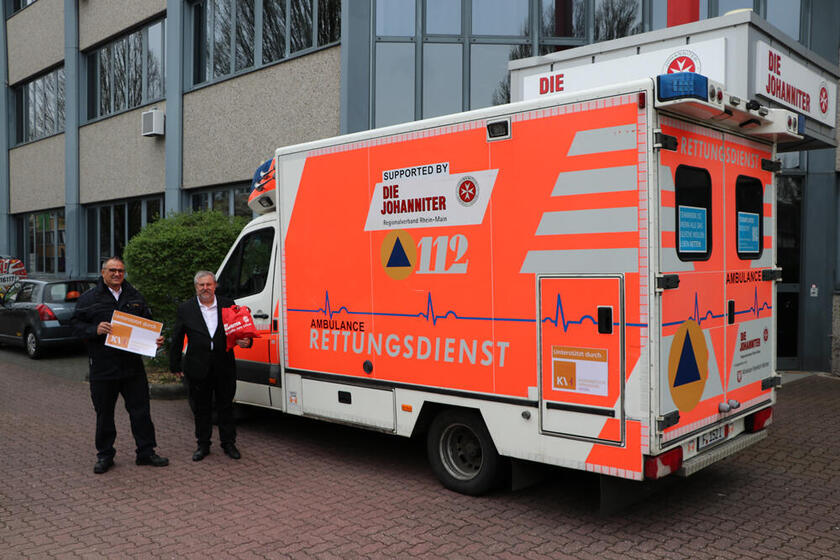 Johanniter-Regionalvorstand Oliver Pitsch (l.) und der Vorstandsvorsitzende der KV Hessen, Frank Dastych (r.), vor dem RTW der Johanniter für die Ukraine.