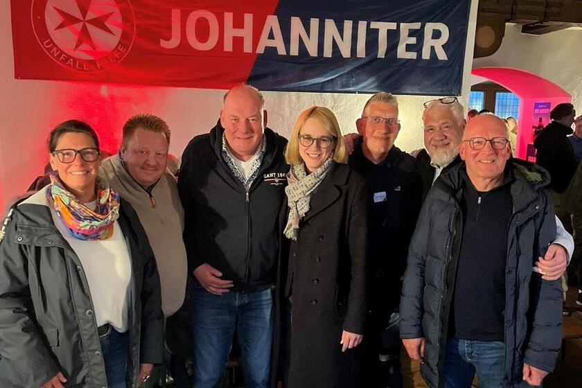Eine Gruppe von sechs Personen vor einem Johanniter-Banner.