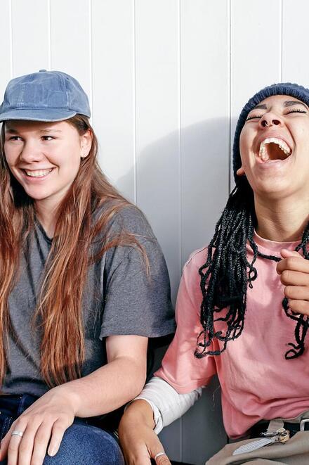 Zwei junge Frauen lachen zusammen